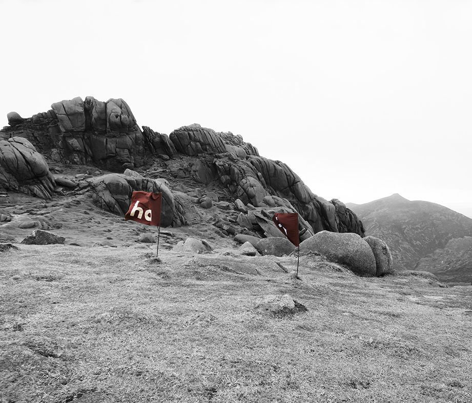 Image of two 'ha ha' flags on the summit of Bearnagh Mountain - displaying 'ha ha' partially.